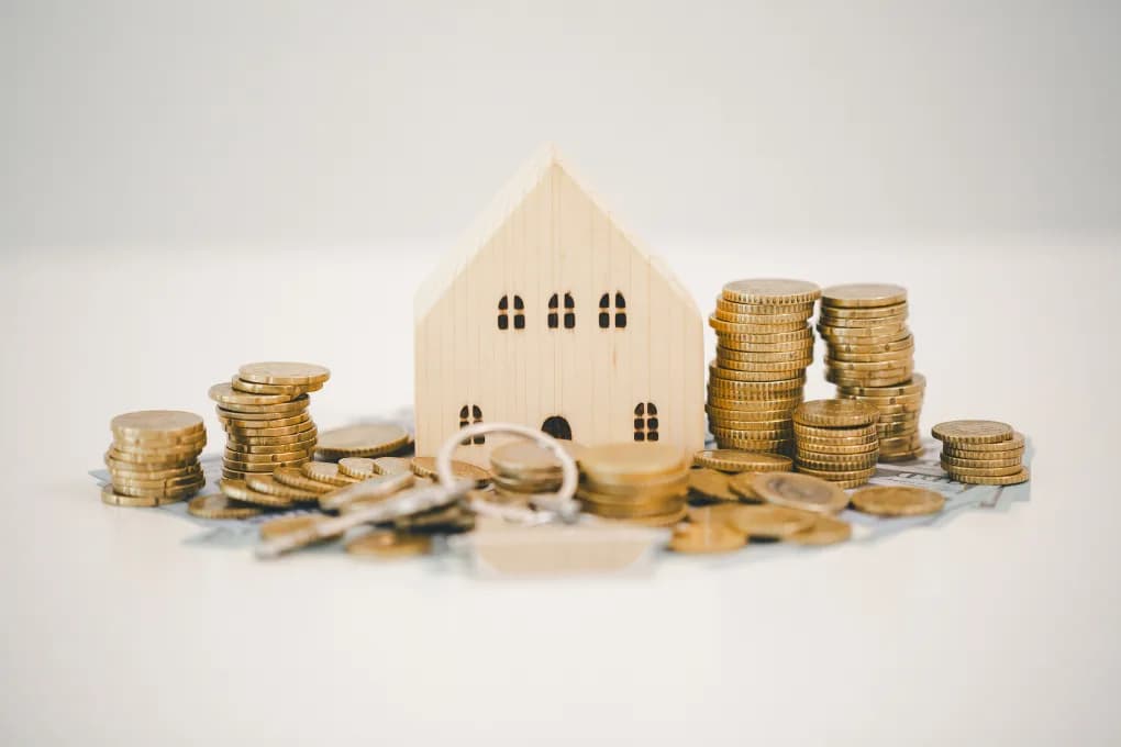 Toy house with coins and money on a table.